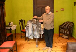 Andrzej Banaś prezentuje pasiak, który znalazł na strychu rodzinnego domu przy ul. Górnickiego 7 w Oświęcimiu