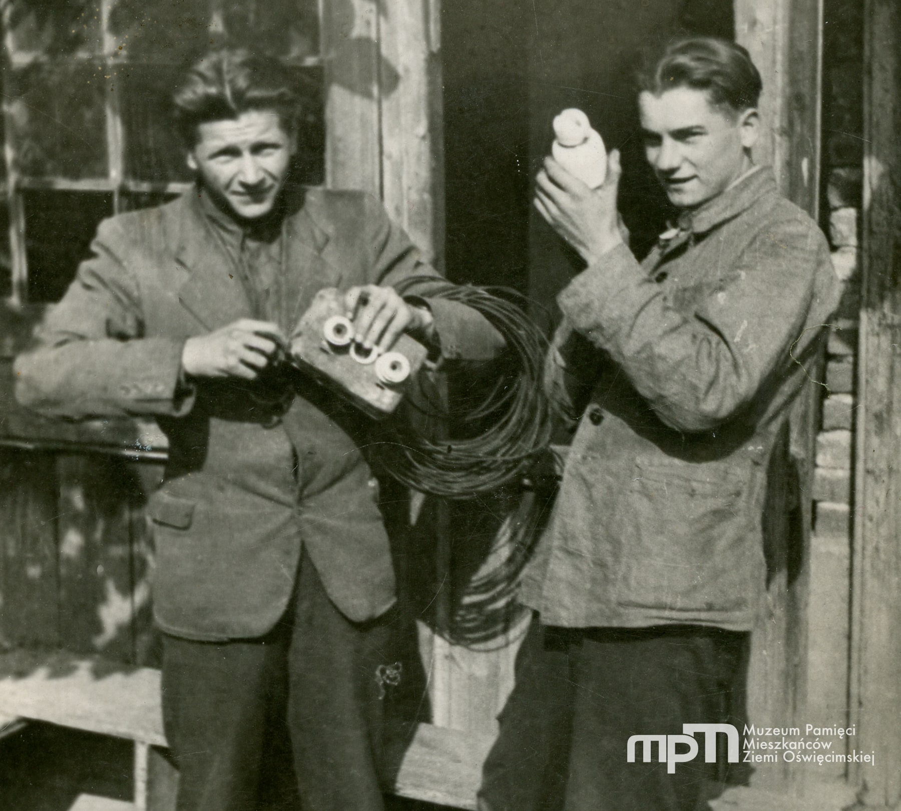 Jan Zajas (z lewej) stoi z kolegą (imię i nazwisko nieznane) przed budynkiem. Zdjęcie zrobione w czasie niemieckiej okupacji.