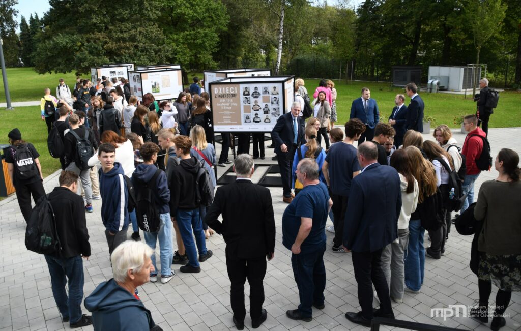 Uczestnicy wernisażu zwiedzają wystawę przed budynkiem Muzeum Pamięci Mieszkańców Ziemi Oświęcimskiej