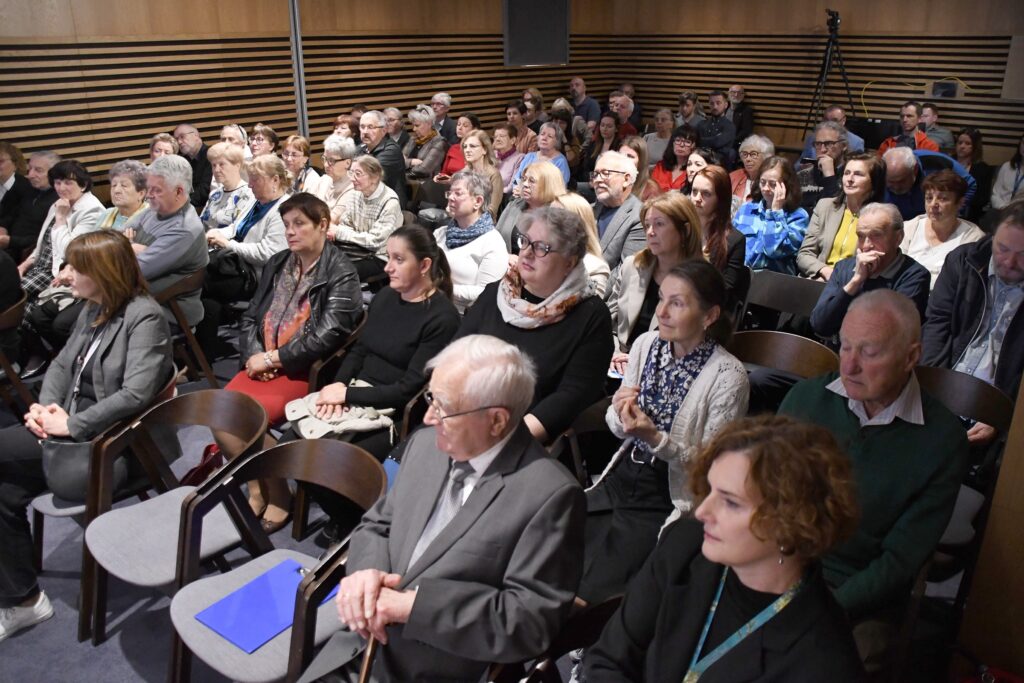 Na zdjęciu uczestnicy konferencji, którzy siedzą na widowni. 