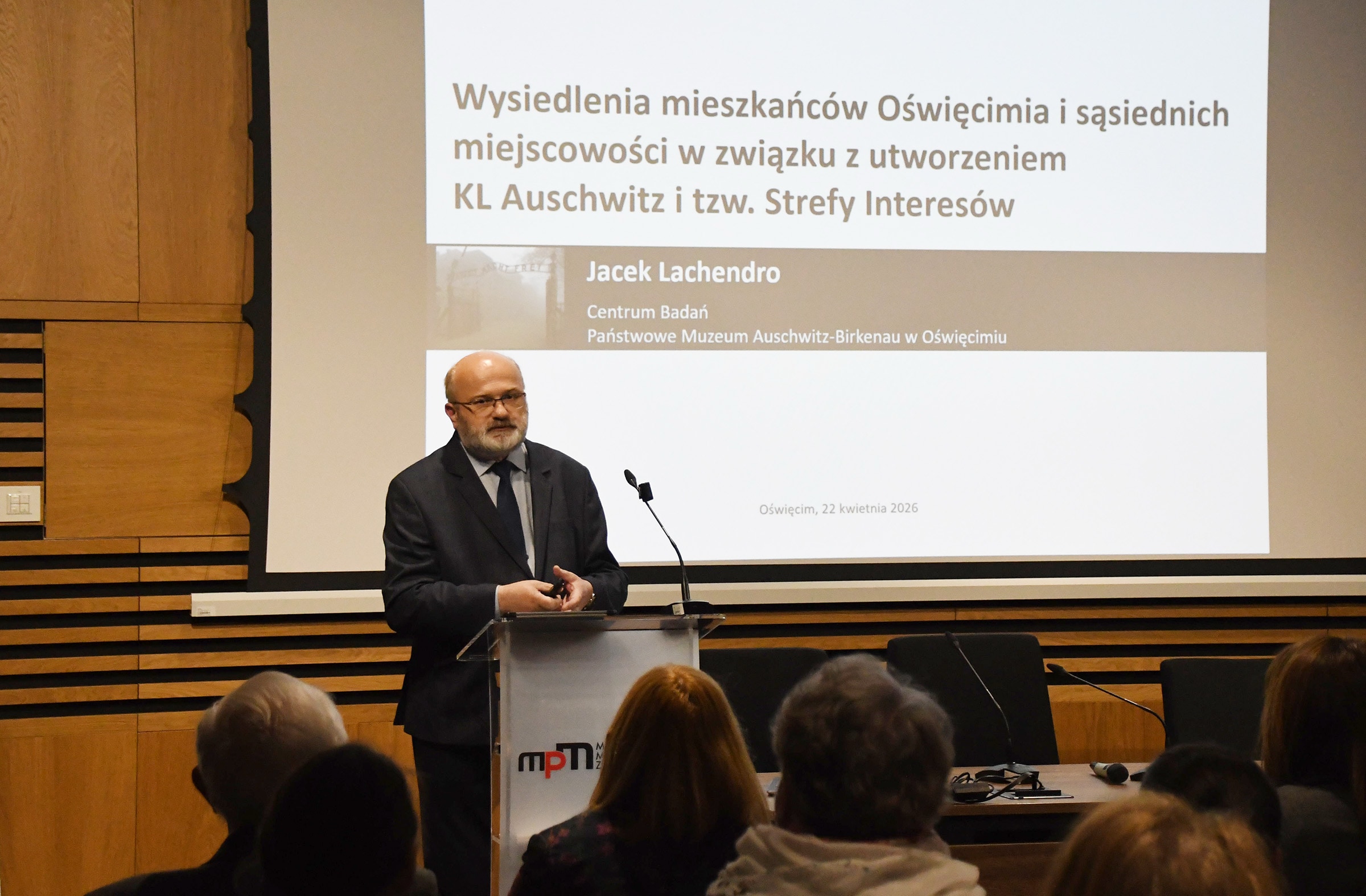Zdjęcie przedstawia osobę prowadzącą wykład. Tą osobą jest Dr Jacek Lachendro z Centrum Badań Państwowego Muzeum Auschwitz-Birkenau